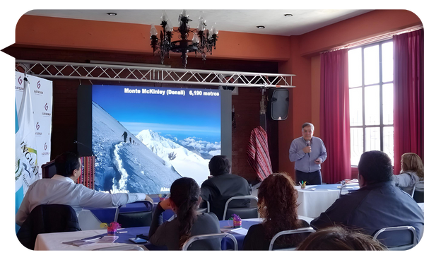 Jaime Viñals presenta una conferencia frente a una pantalla que muestra una imagen del Monte McKinley (Denali) y su altitud.